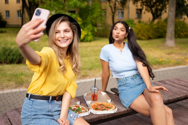 Vorderansichtfrauen, die draußen selfie nehmen