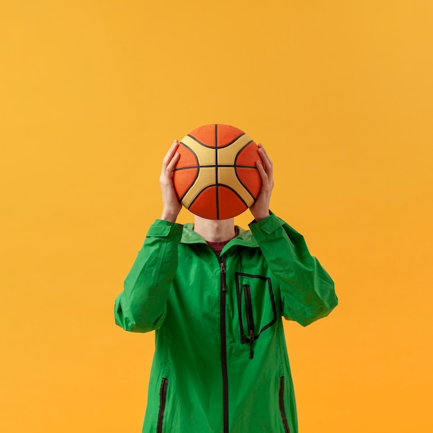 Vorderansichtjunge, der mit Basketballball spielt