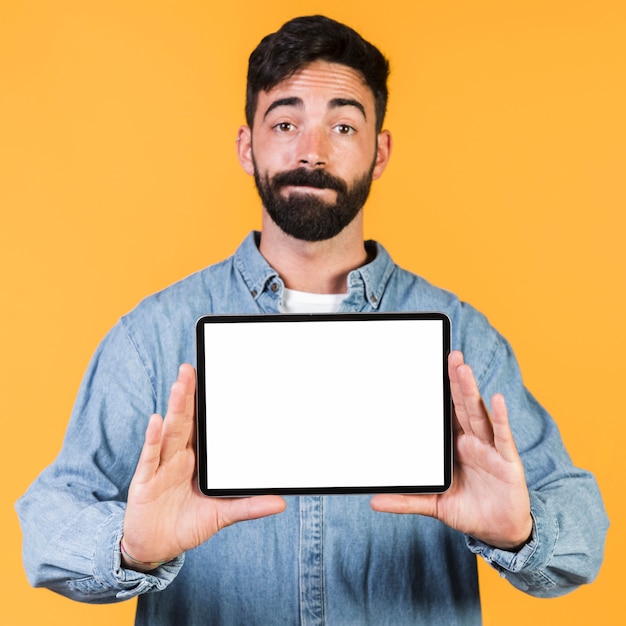 Vorderansichtkerl, der eine Tablette hält