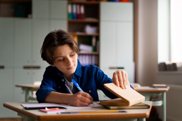 Kostenloses Foto vorderansichtkind, das in der schule betrügt