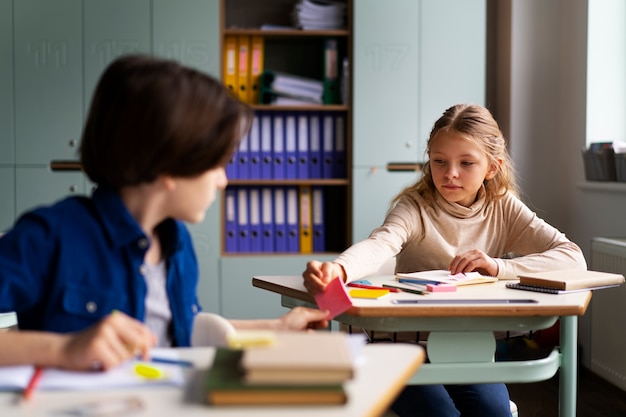 Kostenloses Foto vorderansichtkinder, die in der schule betrügen