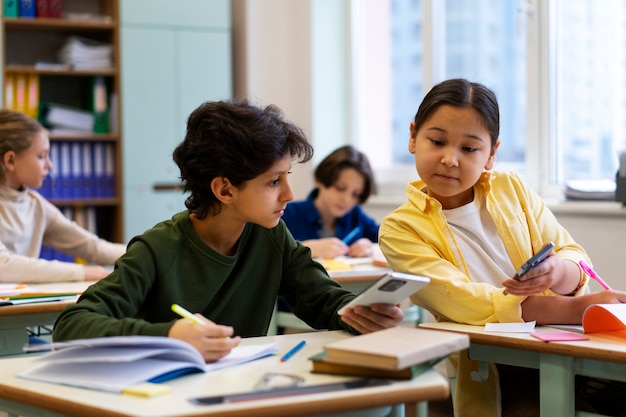 Kostenloses Foto vorderansichtkinder, die in der schule betrügen