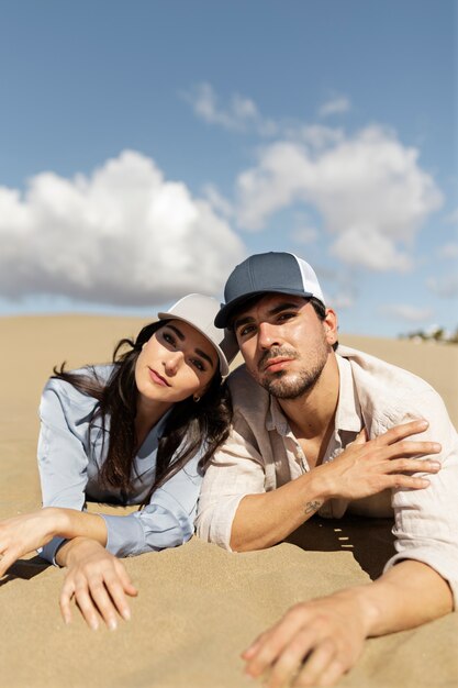 Vorderansichtleute, die auf sand legen