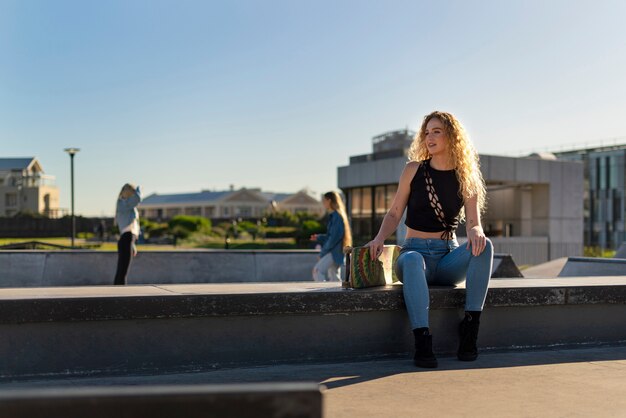 Vorderansichtmädchen, das mit Skateboard sitzt