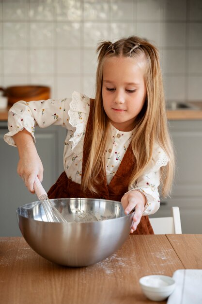 Vorderansichtmädchen, das zu Hause kocht