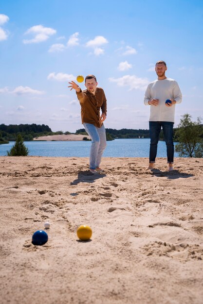 Vorderansichtmänner, die am Strand spielen