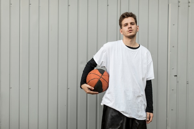 Vorderansichtmann, der mit einem Basketball aufwirft