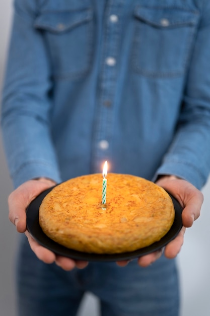 Kostenloses Foto vorderansichtmann, der spanische tortilla hält