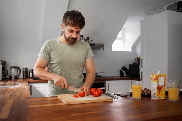 Vorderansichtmann, der Tomaten schneidet
