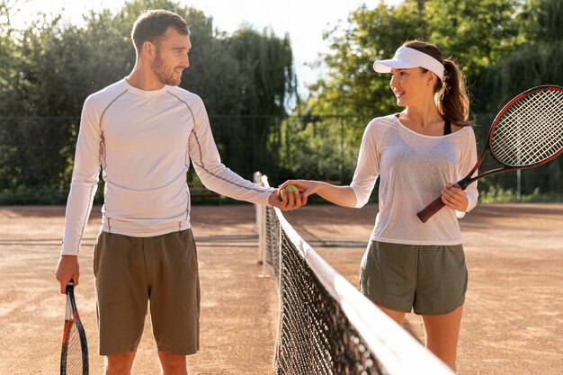 Vorderansichtpaare auf Tennisplatz