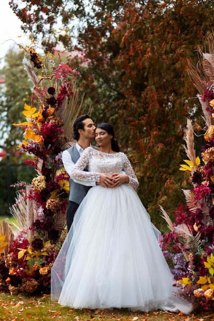 Kostenloses Foto vorderansichtpaare, die bei der hochzeit posieren