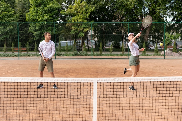 Kostenloses Foto vorderansichtpaare, die tennis spielen