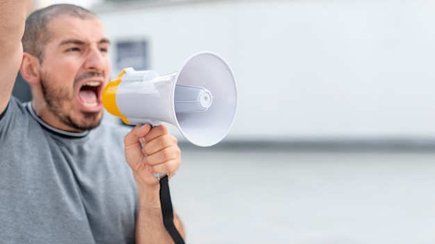 Vorderansichtprotestierender, der mit Megaphon schreit