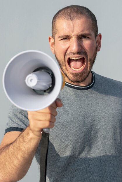 Vorderansichtprotestierender mit dem Megaphonschreien