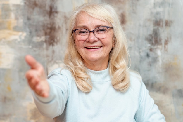 Kostenloses Foto vorderansichtsenior mit der hand ausgedehnt