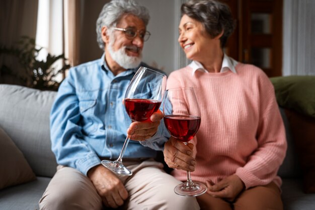 Kostenloses Foto vorderansichtsmiley-älteres paar mit wein