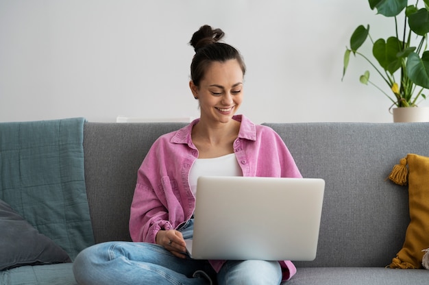 Vorderansichtsmileyfrau, die an Laptop arbeitet