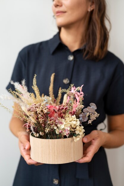 Vorderansichtsmileyfrau, die Blumen hält