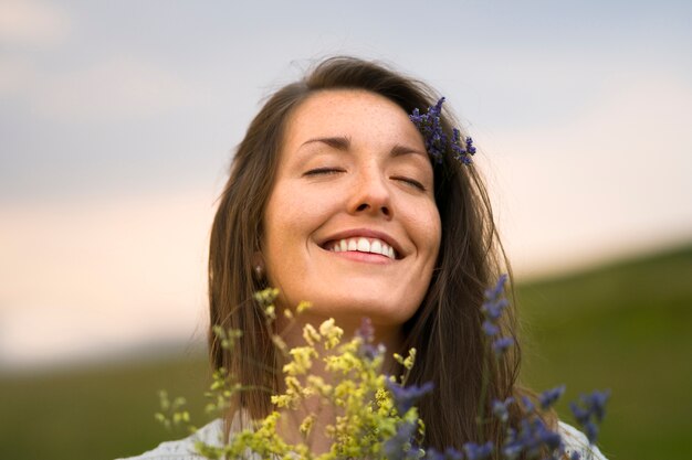 Vorderansichtsmileyfrau, die Blumen hält