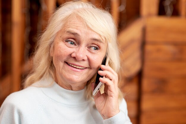 Vorderansichtsmileyfrau, die über Telefon spricht