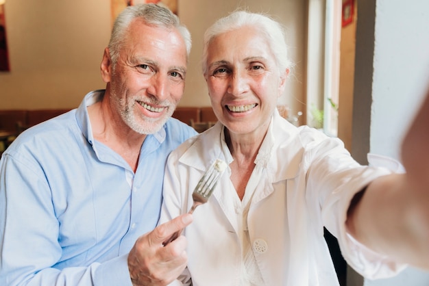 Vorderansichtsmileypaare, die ein selfie nehmen