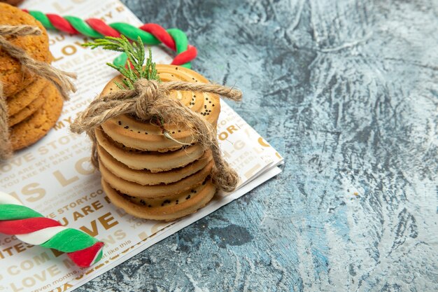 Vorderansichtsplätzchen mit einem Seil Weihnachtssüßigkeiten auf grauem Hintergrundfreiraum gebunden