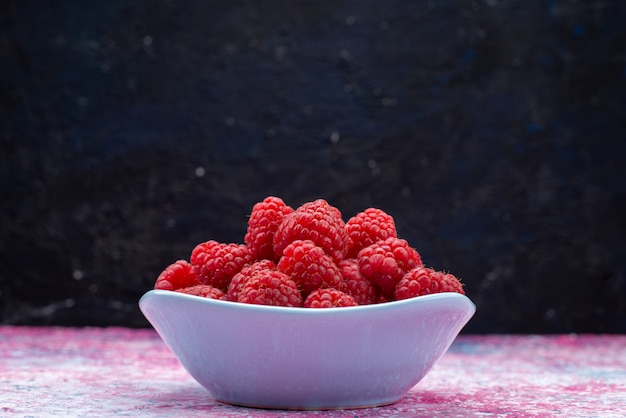 Vorderansichtsteller mit Himbeeren auf dunkler frischer milder süßer Reife