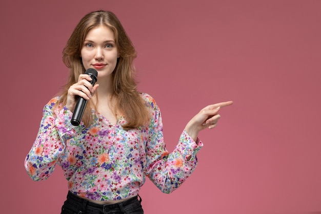 Kostenloses Foto vordere ansicht junge dame lächelnd und zeigt ihre linke seite