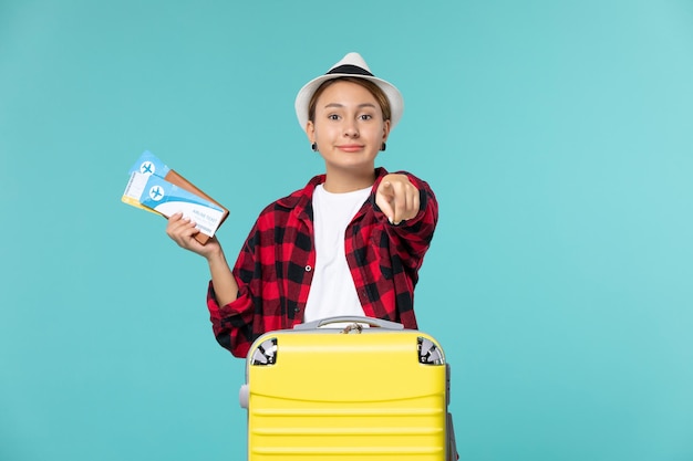 Vordere Ansicht junge Frau, die Brieftasche mit Tickets auf dem blauen Raum hält