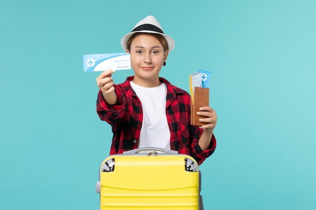 Vordere Ansicht junge Frau, die Brieftasche und Ticket auf blauem Raum hält