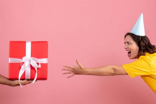 Vordere Ansicht junge Frau, die Geschenk vom Mann auf dem Rosa annimmt