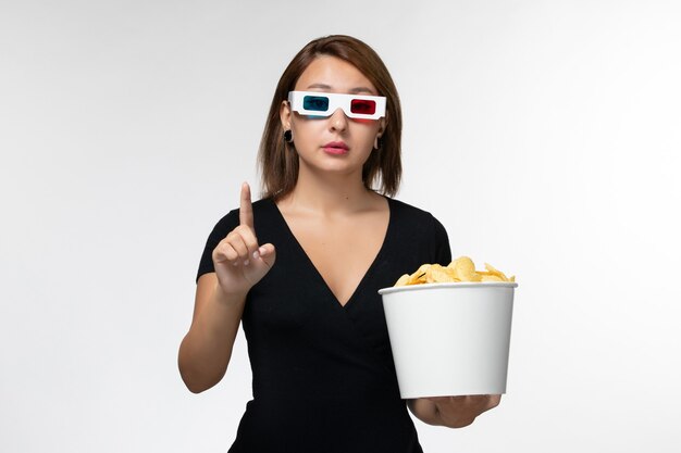 Vordere Ansicht junge Frau, die Kartoffelchips in d Sonnenbrille auf weißer Oberfläche hält