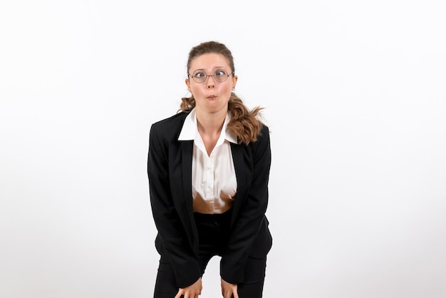 Vordere Ansicht junge Frau in strengen klassischen Anzug suchen mit lustigem Ausdruck auf weißem Hintergrund Frau Job Business Kostüm weibliche Arbeit