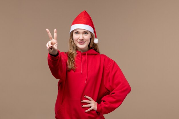 Vordere Ansicht junge Frau zeigt Nummer auf braunem Hintergrund Emotion Weihnachtsfeiertag