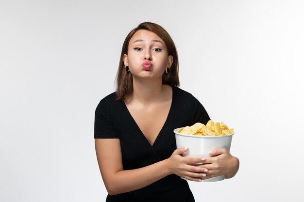 Vordere Ansicht junger weiblicher Haltekorb mit Chips auf weißem Schreibtisch