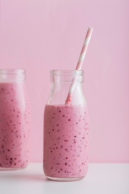 Vordere Ansicht rosa Smoothie-Flaschen mit Strohhalm