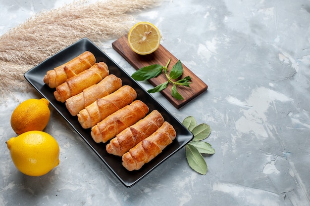 Vordere Ansicht süße Armreifen mit Zitrone auf dem Leuchttisch, Gebäckkuchen backen süßen Zucker