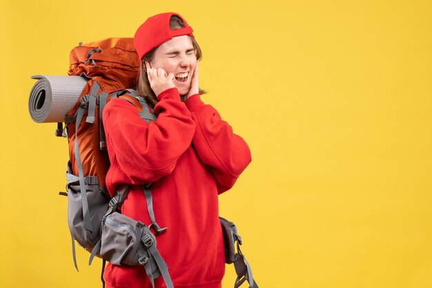 Vordere junge Reisende Frau im roten Rucksack, der Ohren schließt und schreit