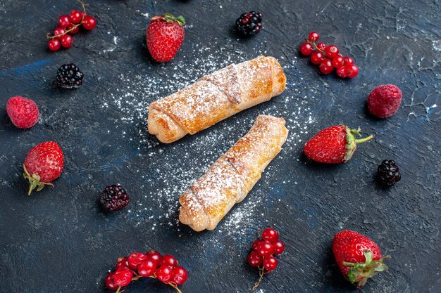 Vordere nähere Ansicht köstliche süße Armreifen mit Füllung lecker mit Früchten und Beeren auf dunklem Boden gebacken