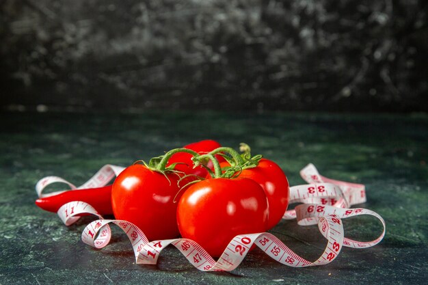 Vordere Nahansicht der frischen Paprika der frischen Tomaten und des Messgeräts auf der Oberfläche der dunklen Farben mit freiem Raum