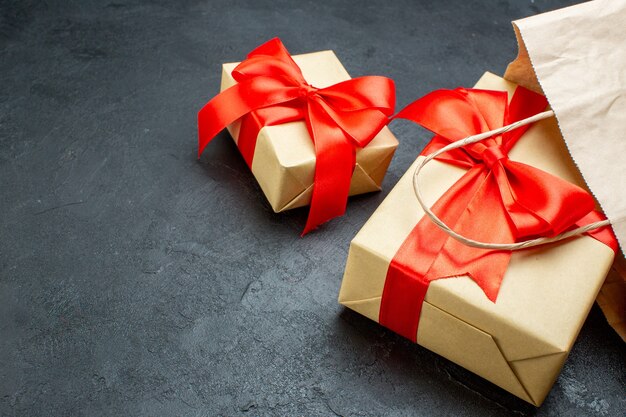 Vordere Nahansicht der schönen Geschenke mit rotem Band auf einem dunklen Tisch