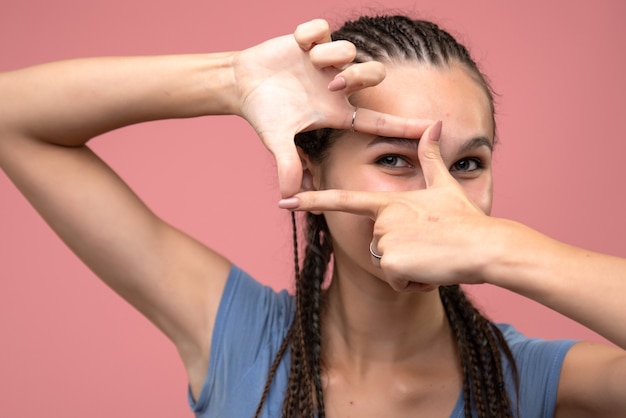 Vordere Nahansicht des jungen Mädchens im Bild, das Pose auf Rosa nimmt