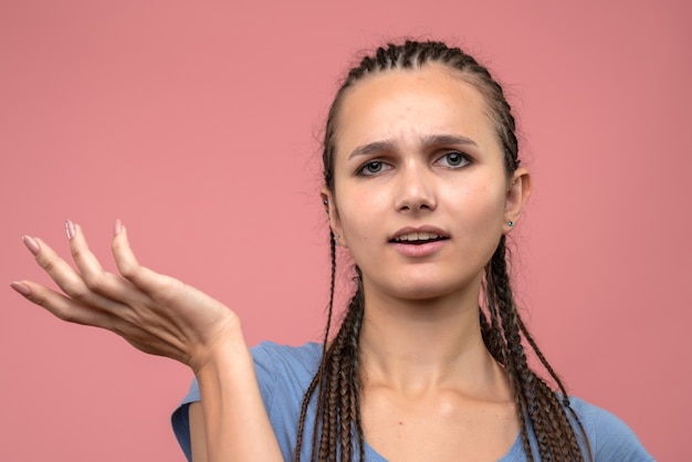 Kostenloses Foto vordere nahansicht des jungen mädchens verwirrt auf rosa