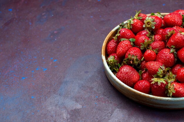 Vordere Nahansicht frische rote Erdbeeren milde Früchte Beeren auf dunkelblauem Hintergrund Beerenfrucht milde Sommernahrung Vitamin reif