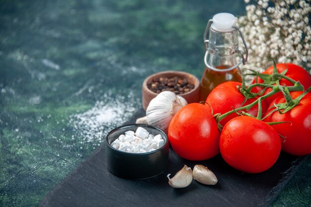 Vordere Nahansicht frische rote Tomaten mit Gewürzen auf dunkler Oberfläche Farbe Mahlzeit Essen Foto Gesundheitsdiät Salat