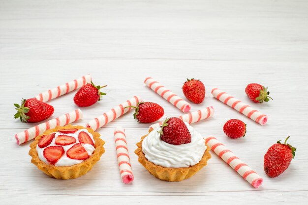 Vordere Nahansicht kleine cremige Kuchen mit frischen Erdbeeren und Süßigkeiten auf Licht, Kuchen süße Frucht Beeren backen