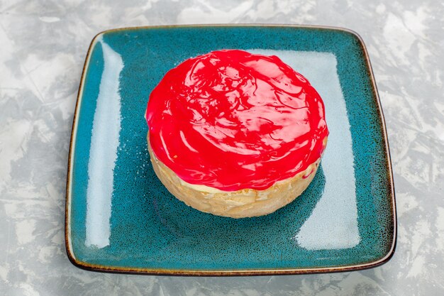 Vordere Nahansicht köstlich aussehender Kuchen kleiner Kuchen mit roter Creme auf der weißen Oberfläche