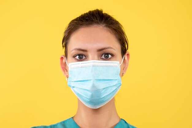 Vordere Nahansicht Ärztin in steriler Maske auf gelbem Hintergrund