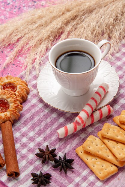 Vordere Nahansicht Tasse Tee mit Zimtplätzchen und Crackern auf rosa Schreibtisch Keks Zucker süß backen