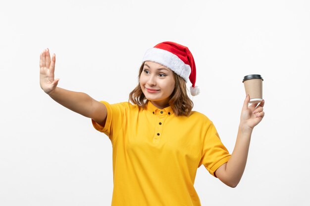 Vorderer Blick junger weiblicher Kurier mit Kaffee auf weißer Wanduniformdienstlieferung